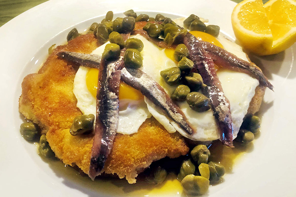 Påskschnitzel på gris med stekt ägg, sardeller och brynt kaprissmör.